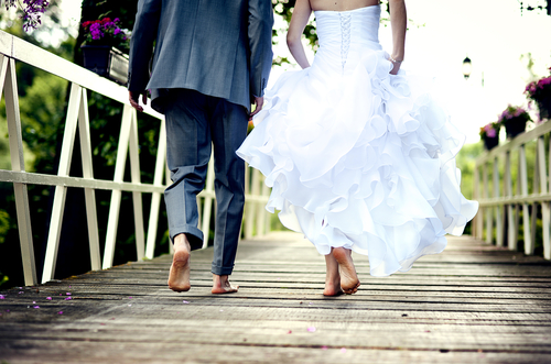 Loveandfriends newly wed couple in wedding dress runnign barefoot together