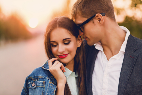 Love and Friends couple in an embrace with girl wearing bright lipstick and man with glasses kissing her head